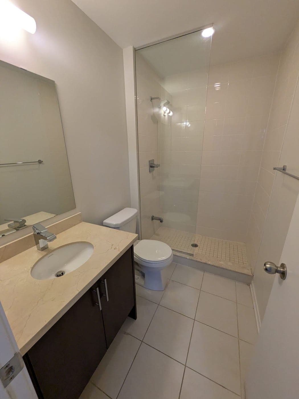 A bathroom with a vanity, mirror and glass shower