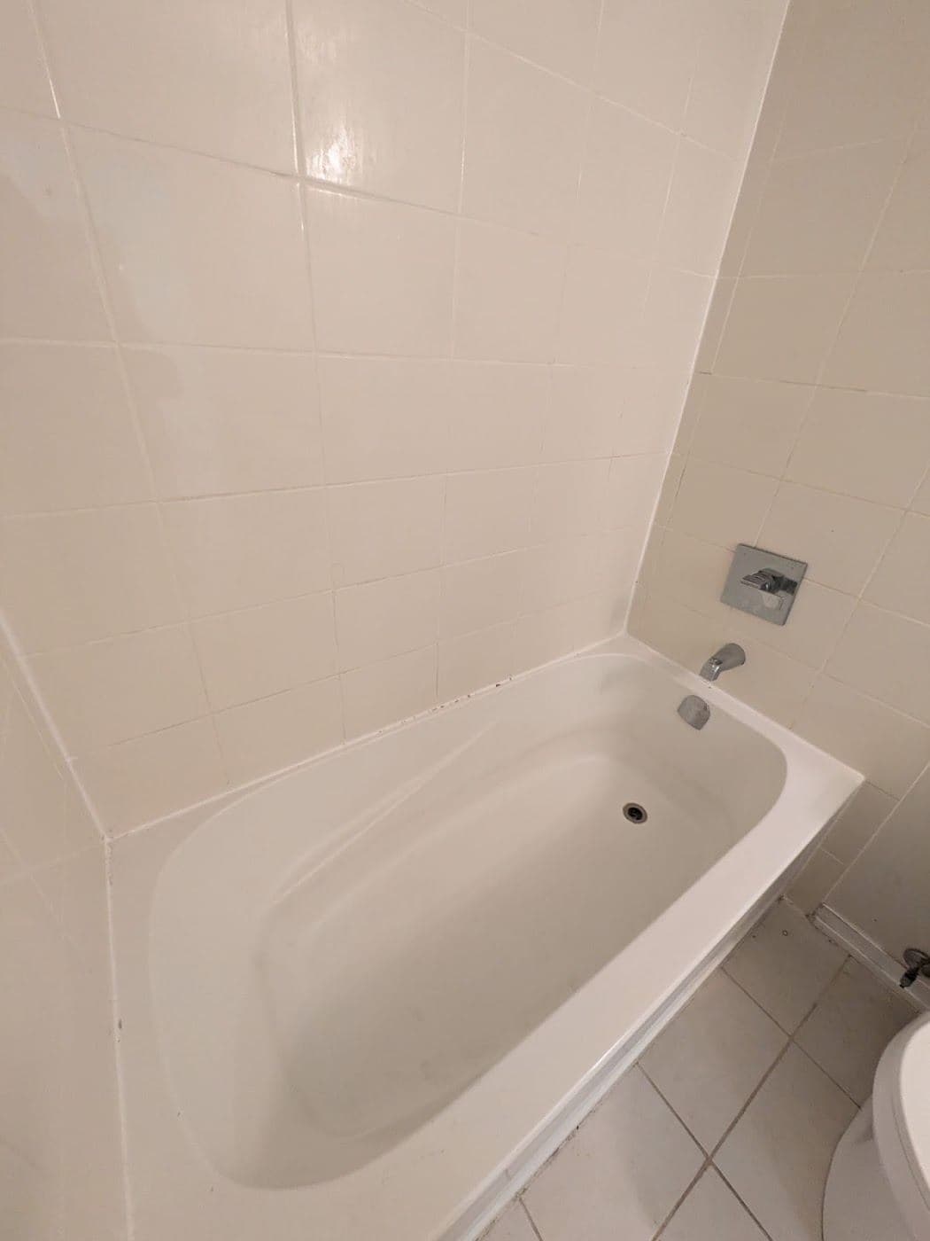 A clean bathtub against large format wall tile