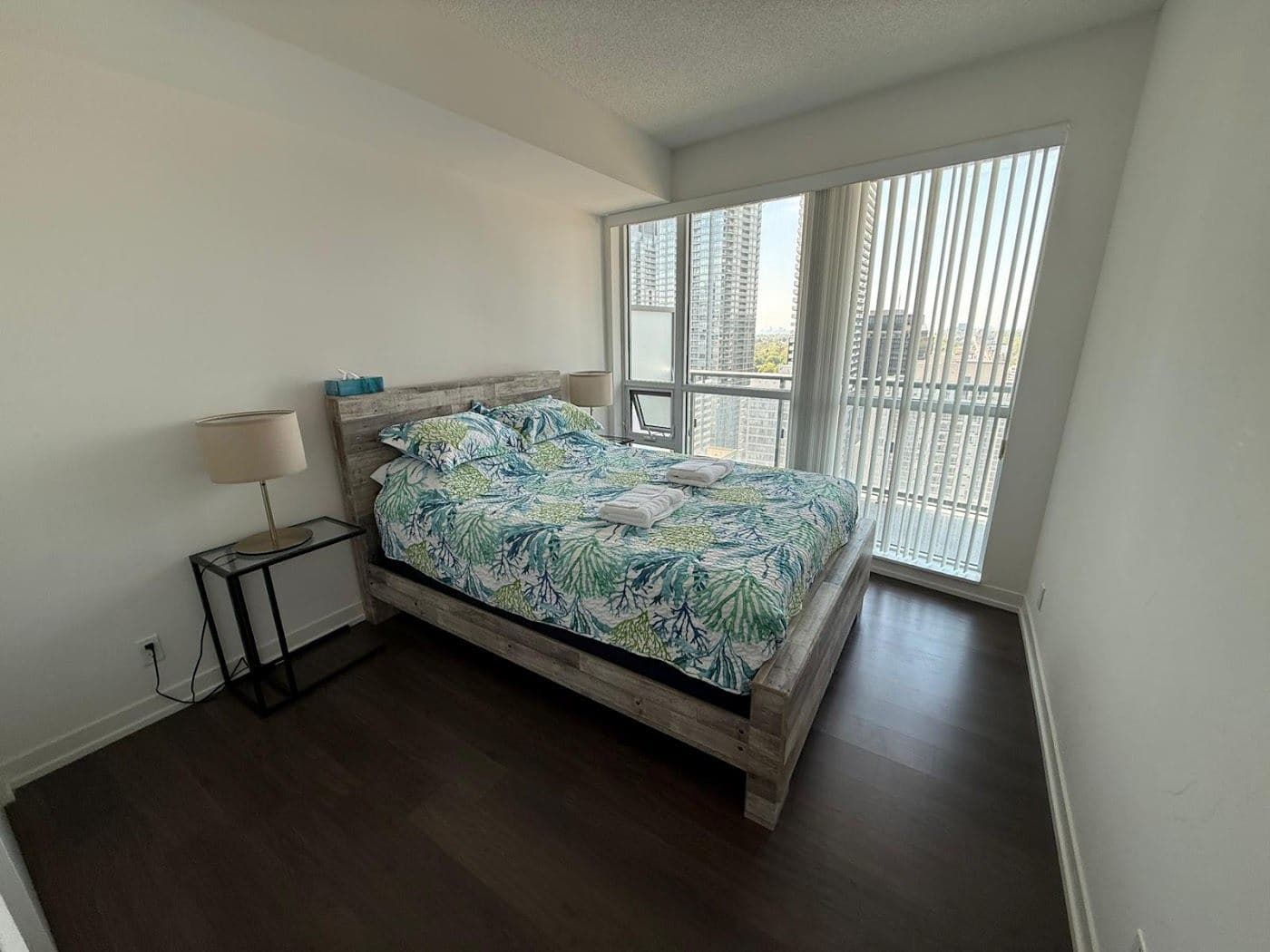 A bedroom with daylight from a tall window