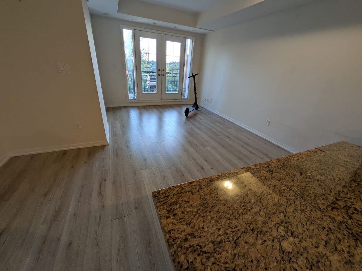 An empty room with clean wood floors and a window