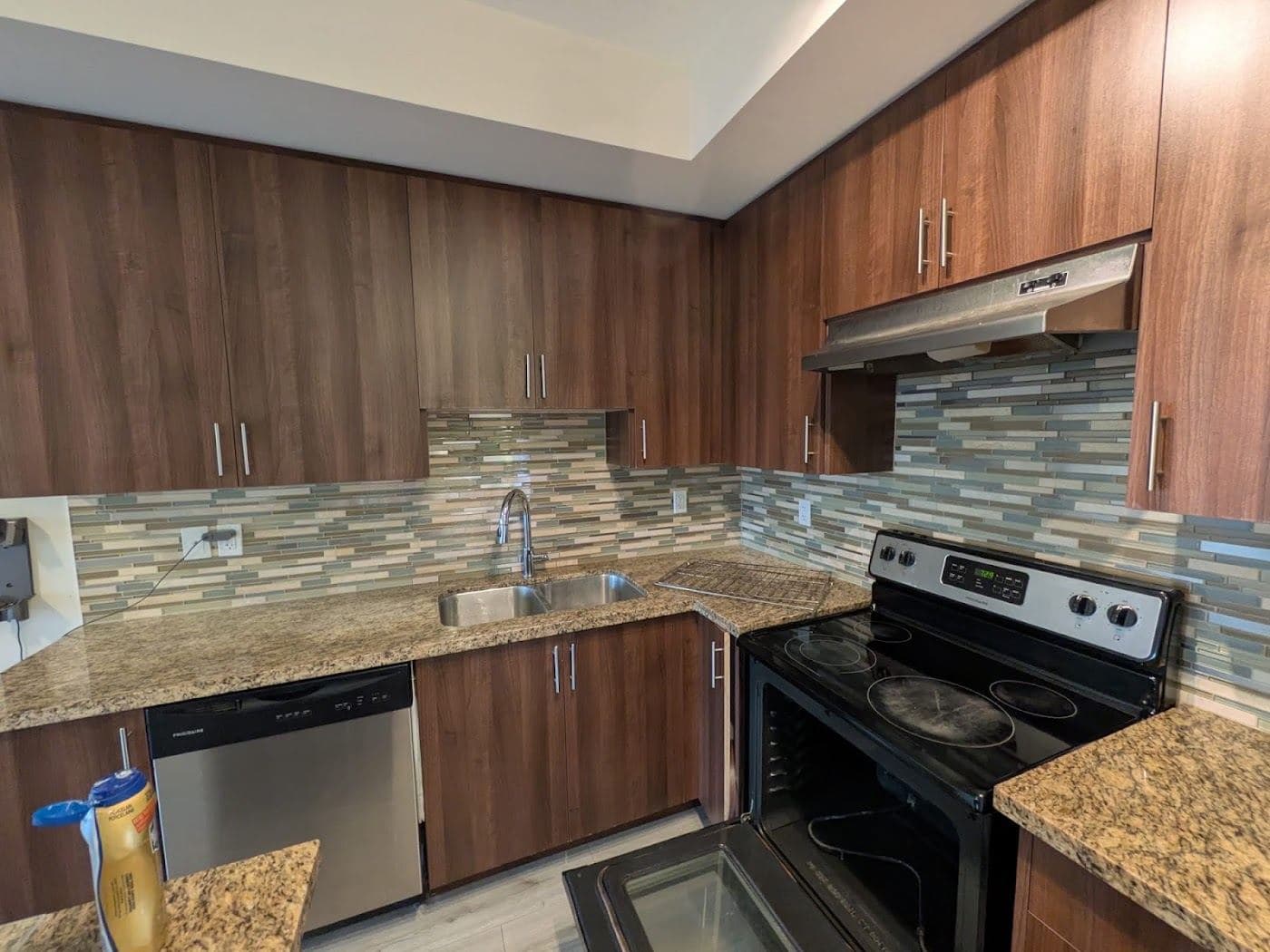 A kitchen with wood cabinets, a tiled backsplash and a range